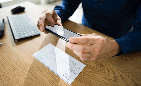 Person taking photo of check with phone