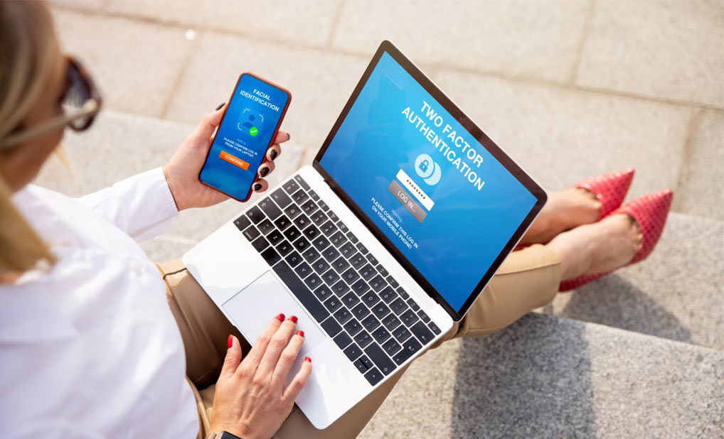 Person logging into computer using two-factor authentication on phone