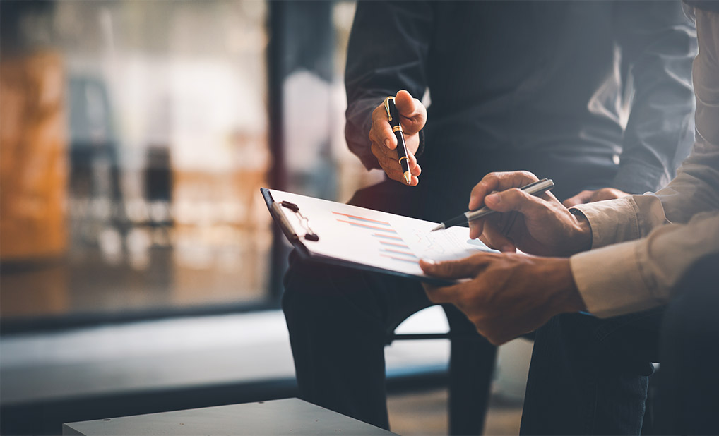 Close up of two people reviewing a chart together