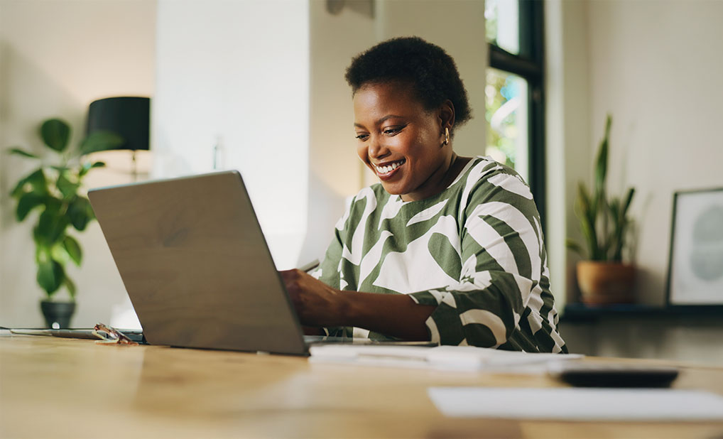 Businessperson looking at laptop and smiling