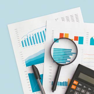papers with graphs on them. there's a magnifying glass, pen, and calculator next to them