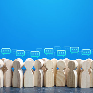 A group of small wooden figures with speech bubbles above their heads