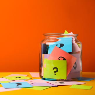 A jar full of notes with question marks on them.